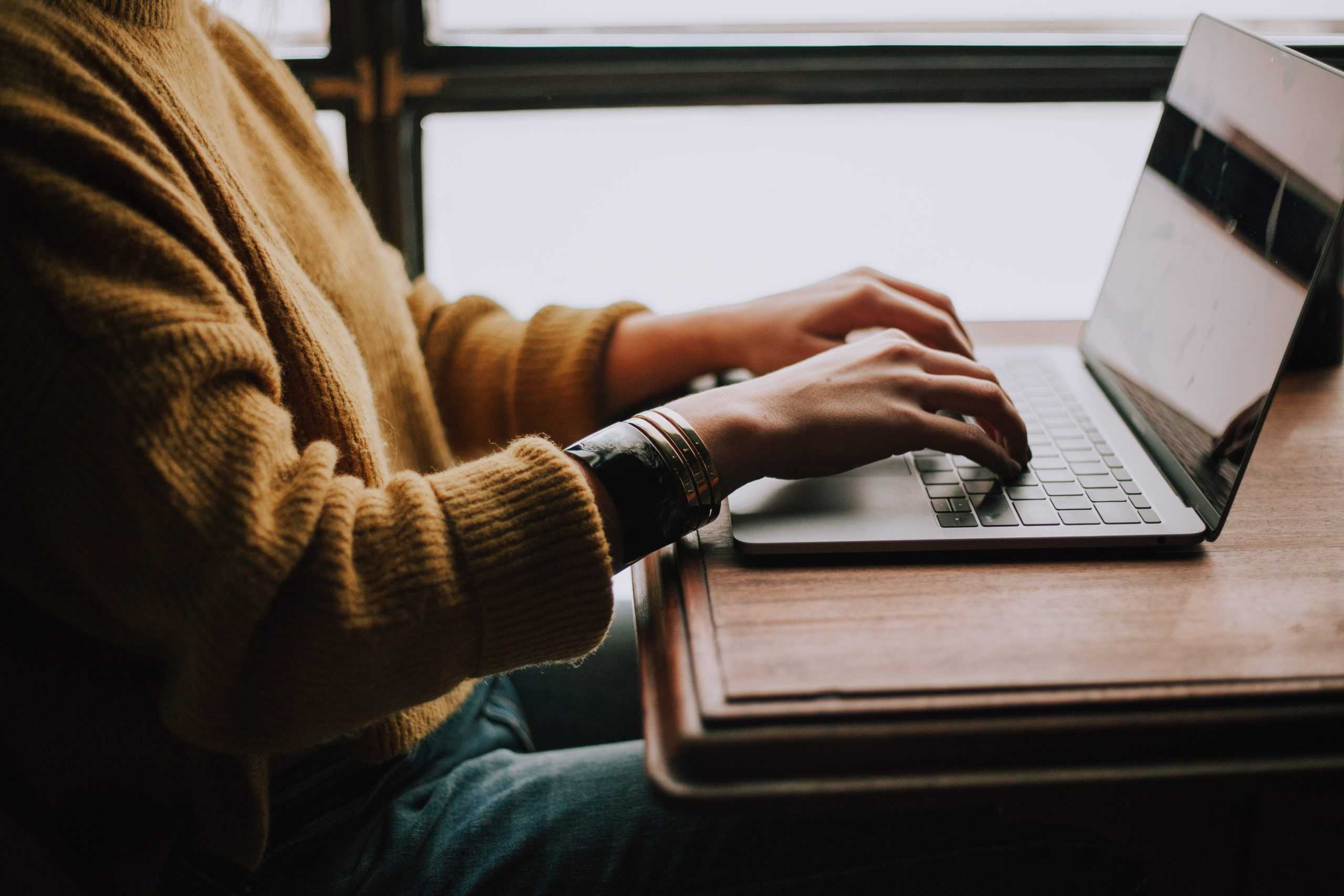 Woman sitting at her computer performing search engine optimization.